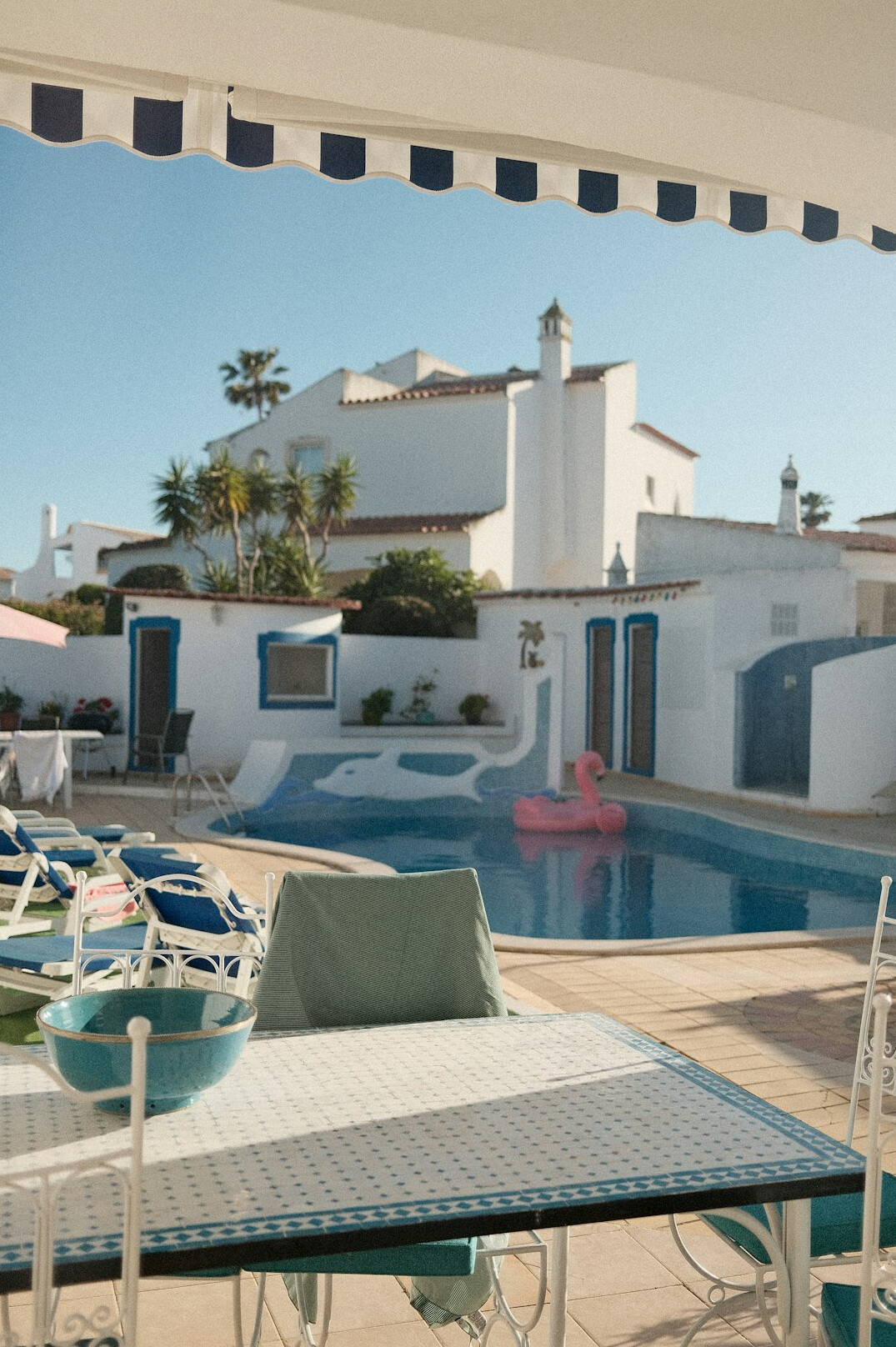 White Mediterranean villa exterior with palm trees and swimming pool